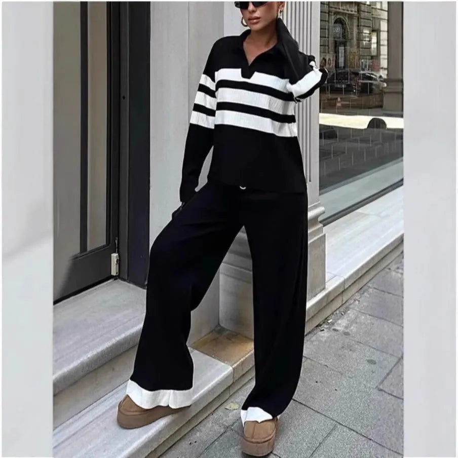 Women's black and white striped knitted two-piece set with polo collar top and full-length trousers.