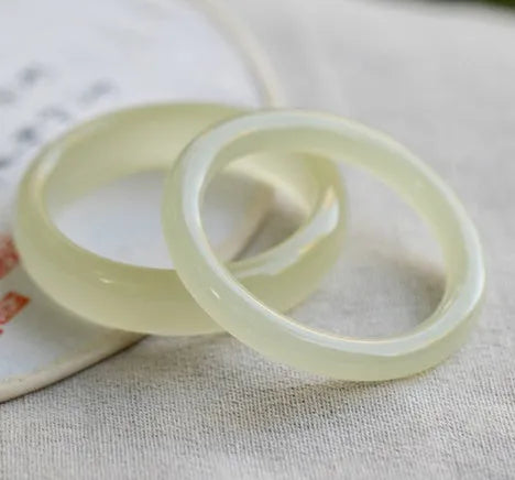 Natural ice silk jade round bar bracelet on a white background, showing its smooth texture and solid form.