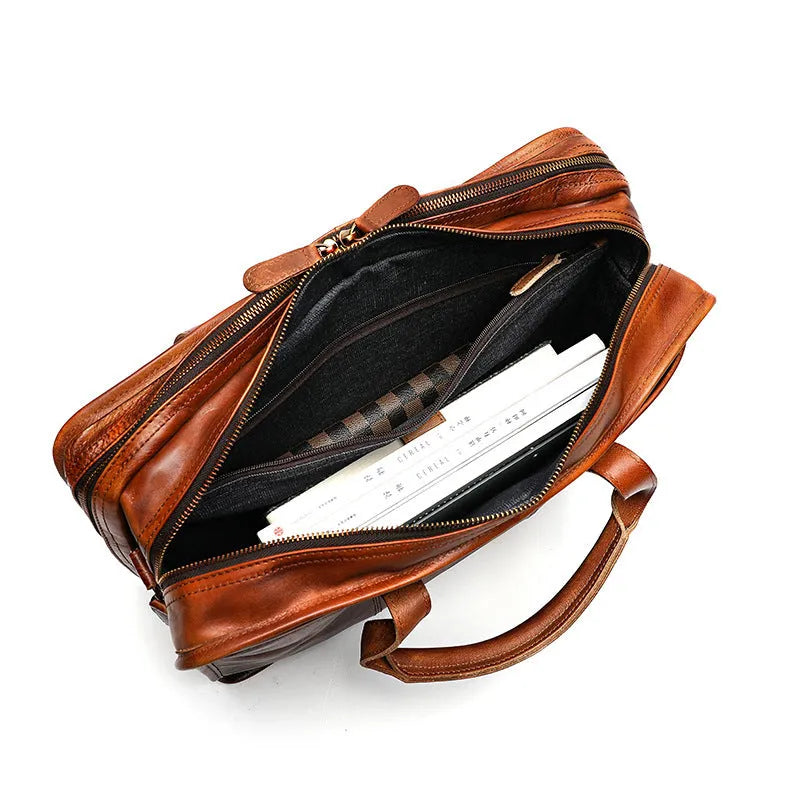 Brown vintage leather men's briefcase open showing internal laptop sleeve and multiple organisation pockets