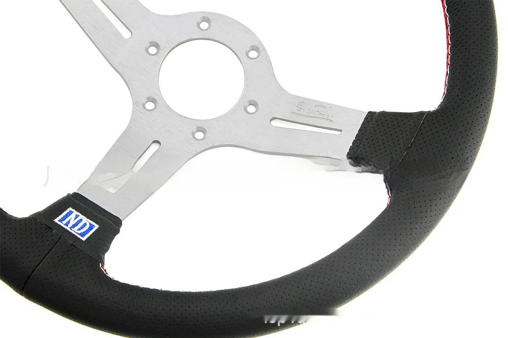 Black leather 14-inch steering wheel with deep concave dish and aluminium skeleton on a plain background.