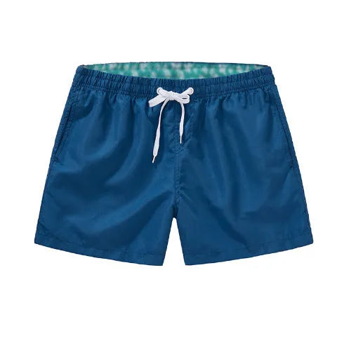 Men's straight-leg polyester beach shorts in black, shown on a model, highlighting the distressed finish and casual fit.