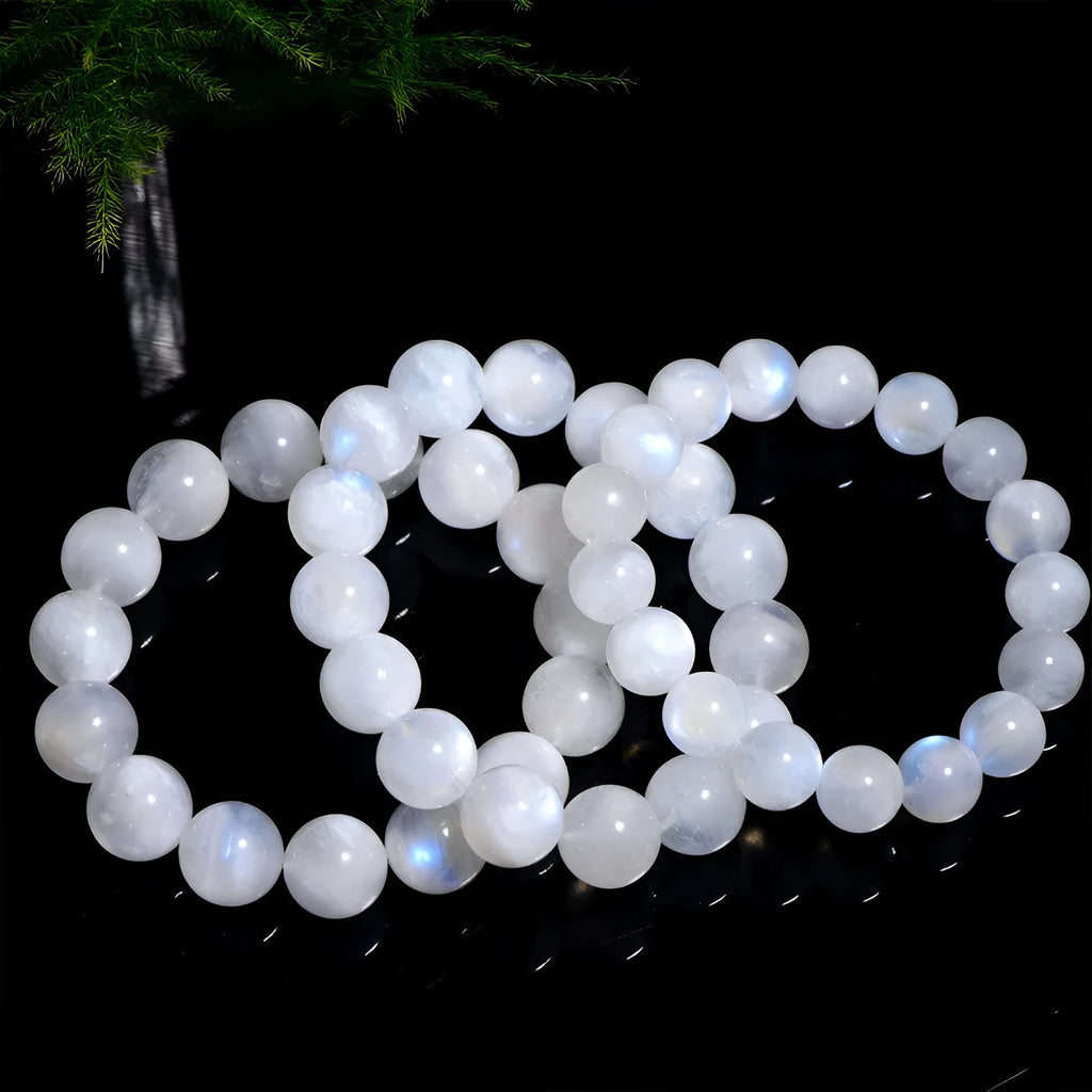 Natural blue moonlight round moonstone bead bracelet on a wrist, showing adjustable closure.