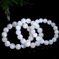 Natural blue moonlight round moonstone bead bracelet on a wrist, showing adjustable closure.