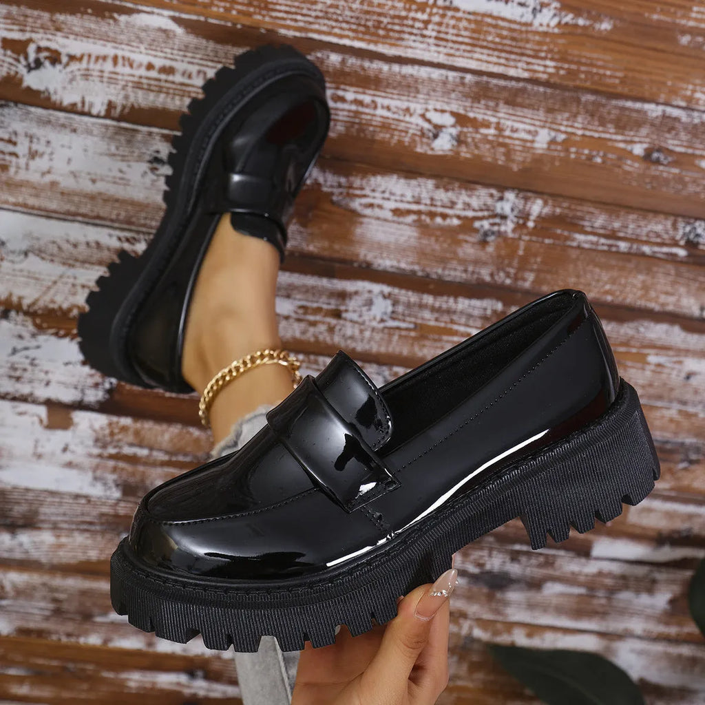 Black slip-on loafers with a chunky platform heel and thick rubber sole.