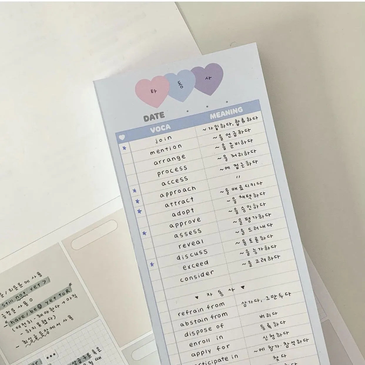 Half-B5 size vertical notepad with coloured cover, shown open to show lined pages.