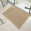 Beige checkered non-slip bathroom carpet mat on tiled floor.