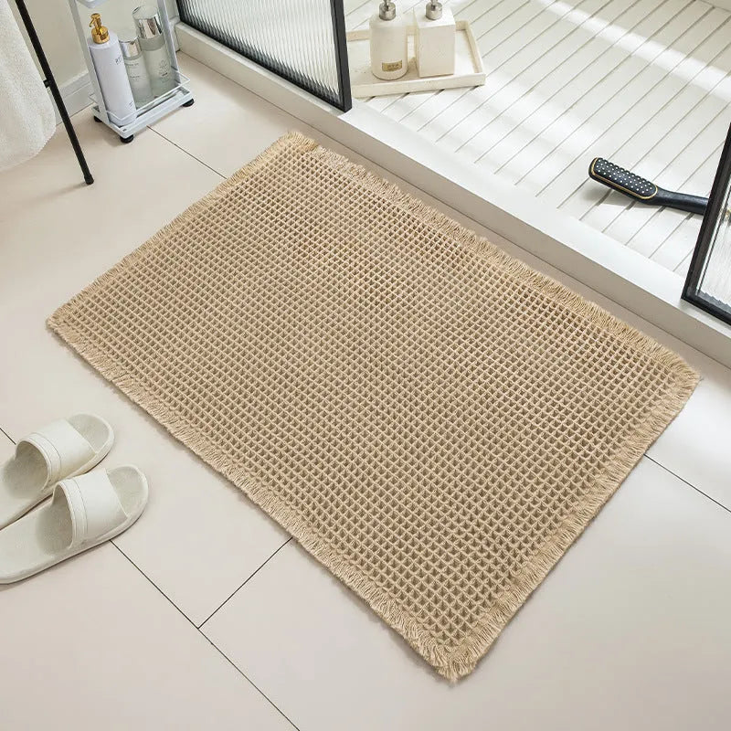Beige checkered non-slip bathroom carpet mat on tiled floor.