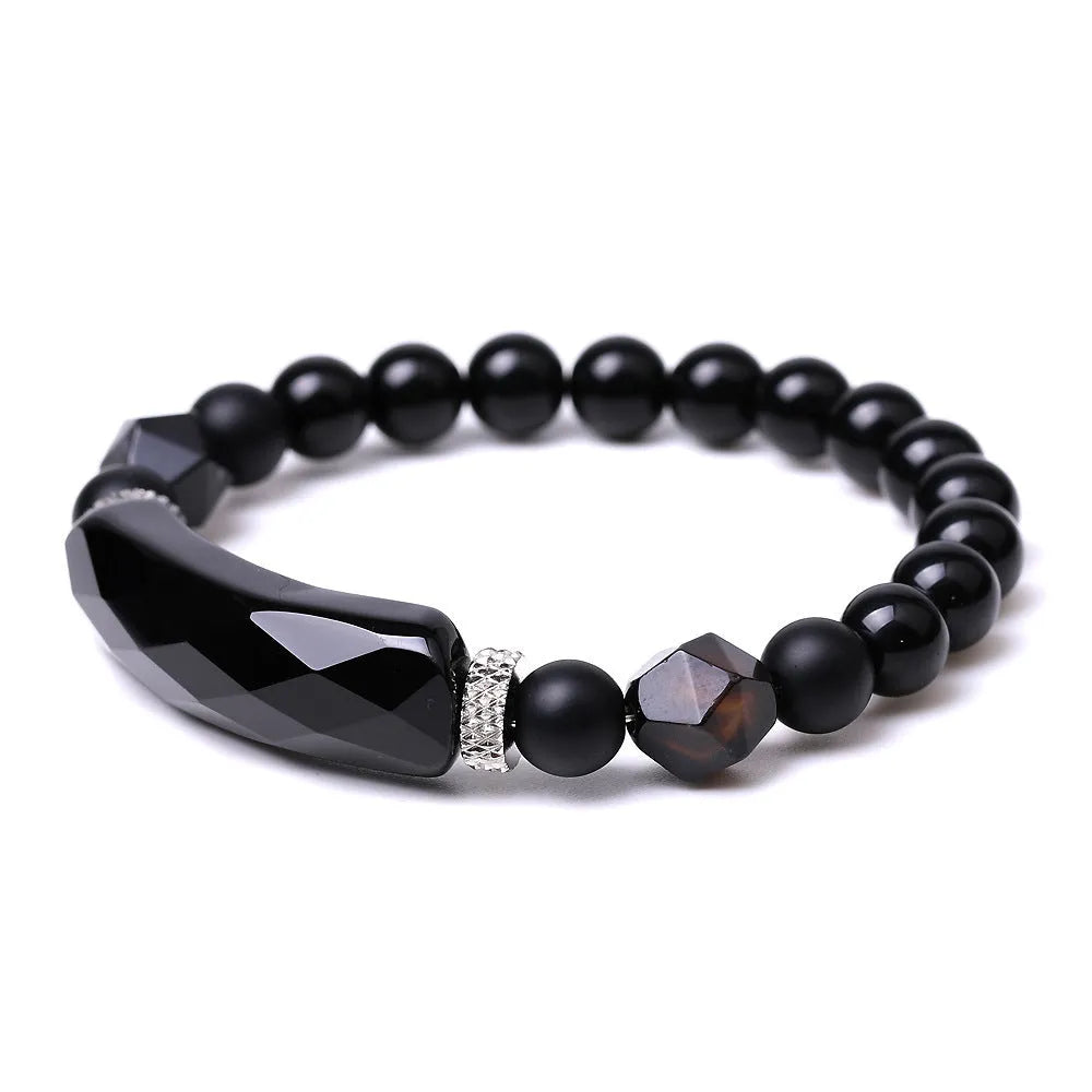 Close-up of a handmade diamond-cut black agate bracelet with geometric, fan-shaped design elements.