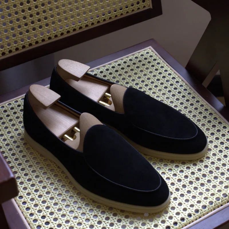 Men's brown genuine leather handmade loafers on a white background, showing the low-cut slip-on design and textured sole.