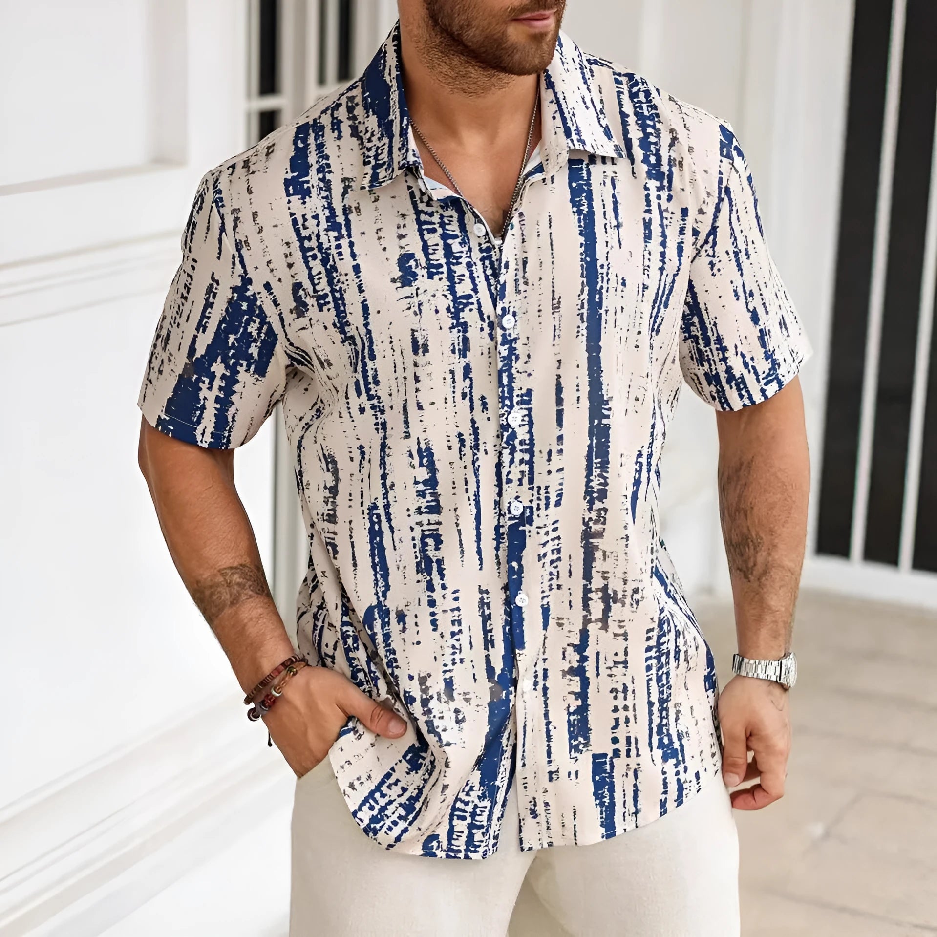 Man wearing a short sleeve striped casual shirt in blue, showing 3D print detail and lightweight fabric.