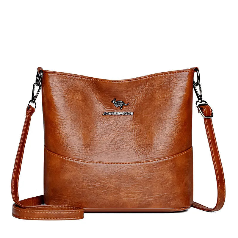 Women's soft leather bucket shoulder bag in solid colour with sewing line details and organisational pockets