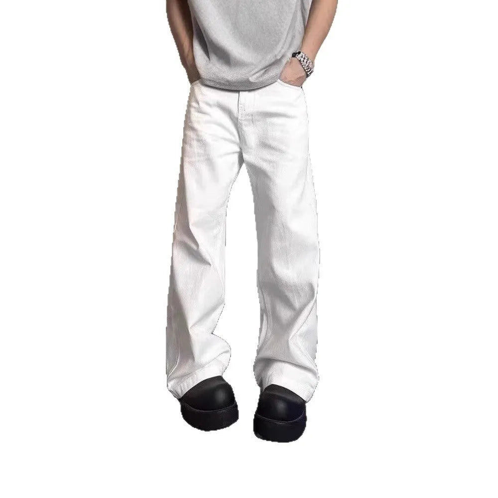 A man wearing white loose straight-leg cotton jeans with a mid-waist and zipper fly.
