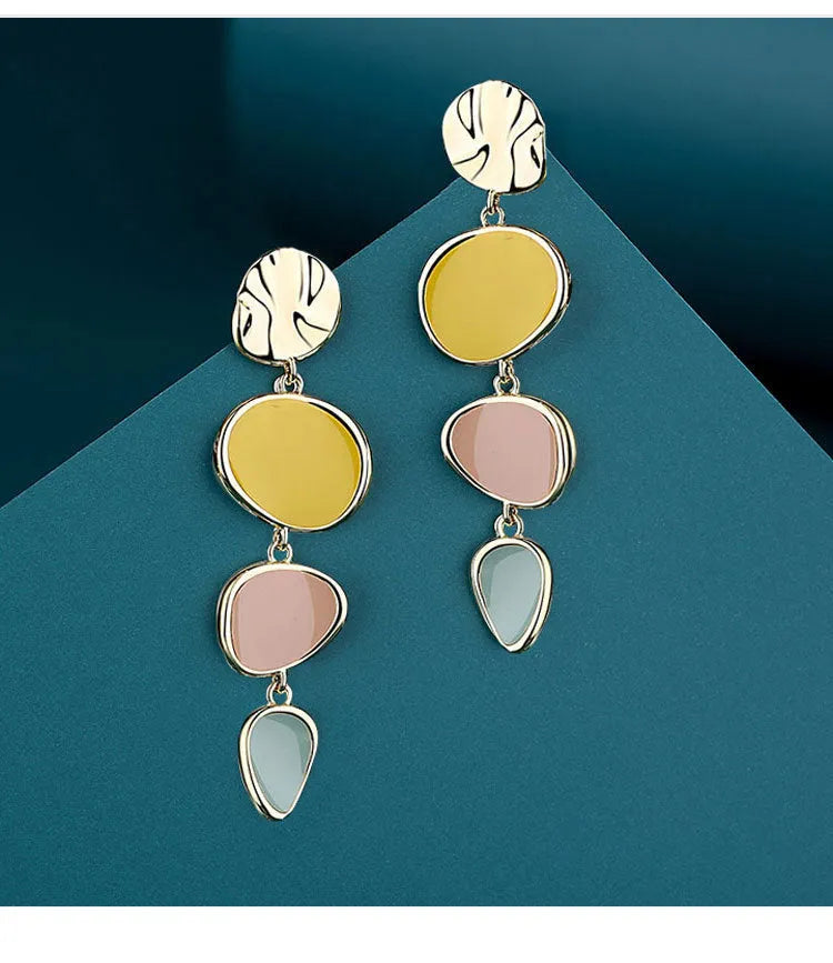Sterling silver alloy Morandi three-colour oil drip simple wafer disc earrings on a white background.