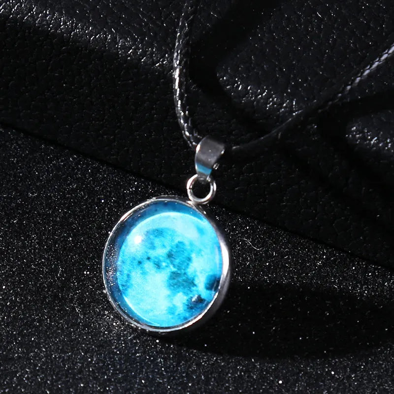 Luminous moon and star constellation pendant necklace with a silver-tone chain on a black background.
