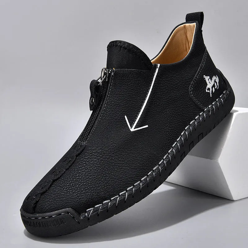 Men's black leather casual boot with front zip, round toe, and rubber sole on a white background.