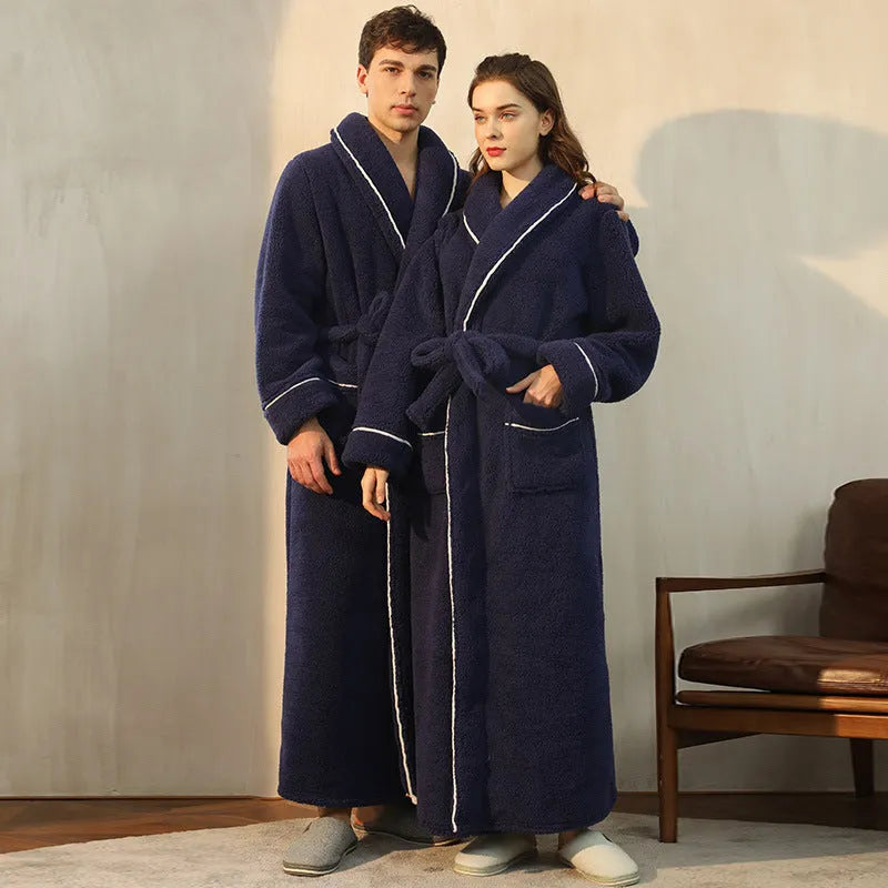 A man and woman wearing matching navy blue thick flannel bathrobes, showcasing the wrap-around design and plush fabric.