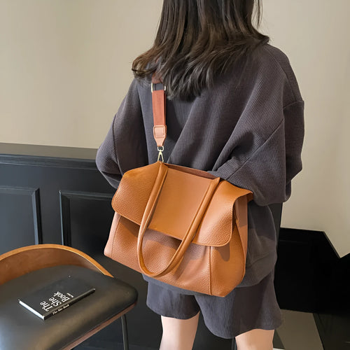 A brown PU tote bag with double shoulder straps and visible sewing thread detail.