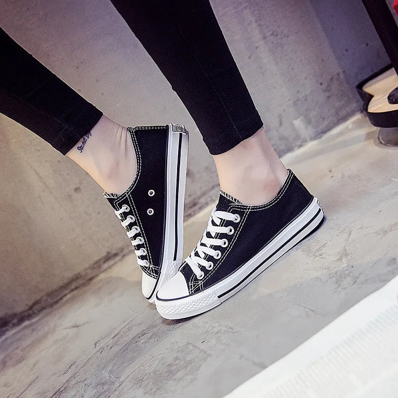 A pair of solid colour canvas lace-up trainers for women on a summer background.