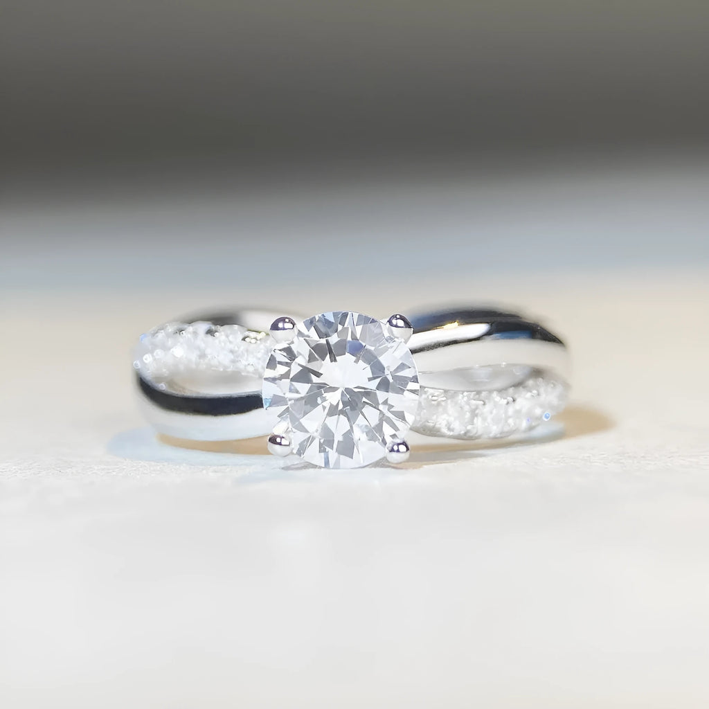 Geometric silver moissanite ring with a 1 karat stone and twisted band.