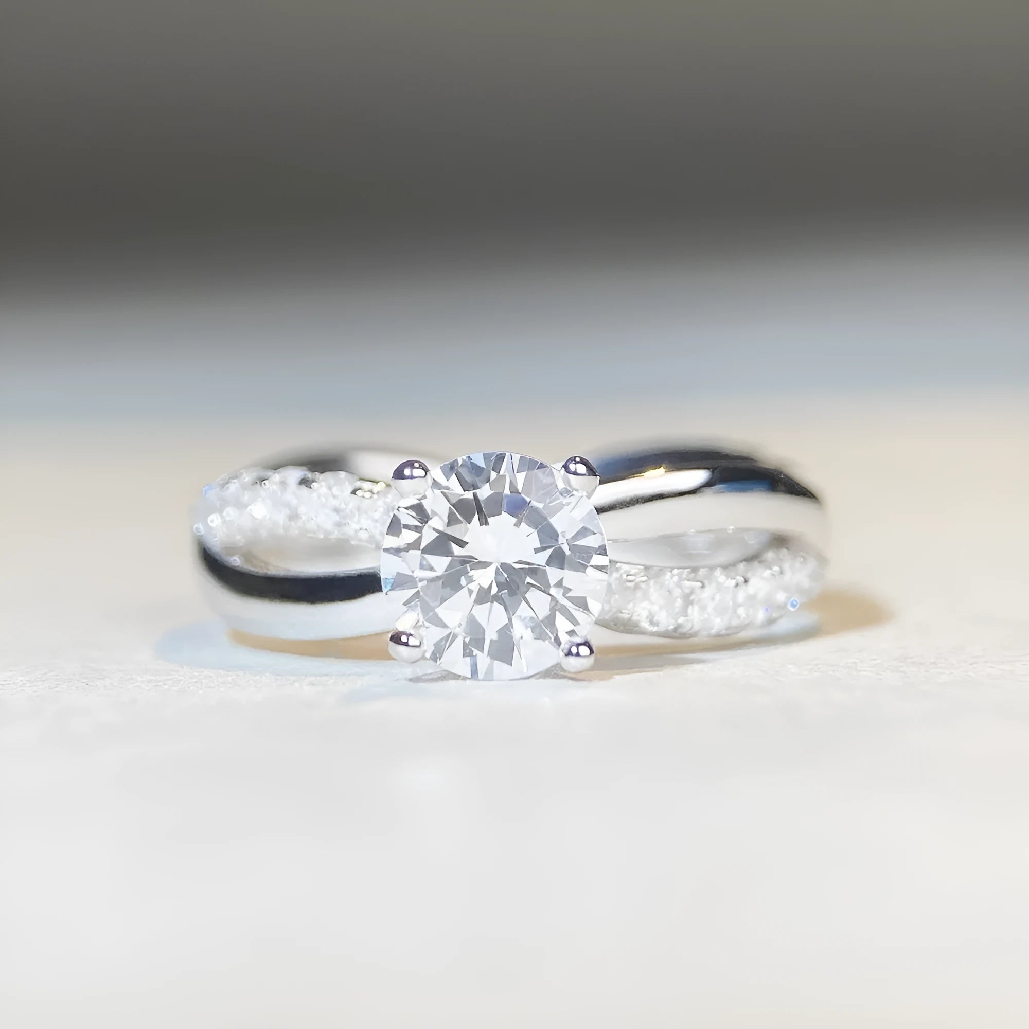 Geometric silver moissanite ring with a 1 karat stone and twisted band.