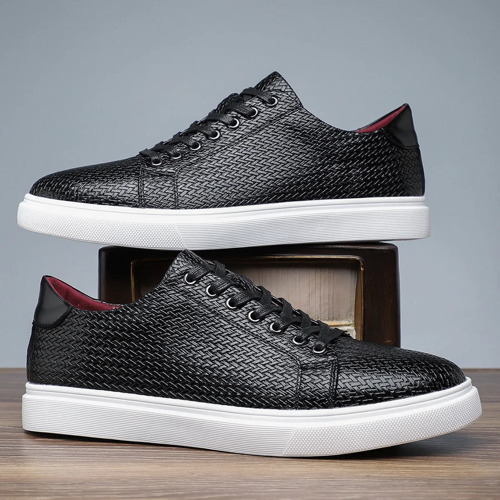 Men's low-top black leather-style shoes with decorative stitching and a rubber sole.