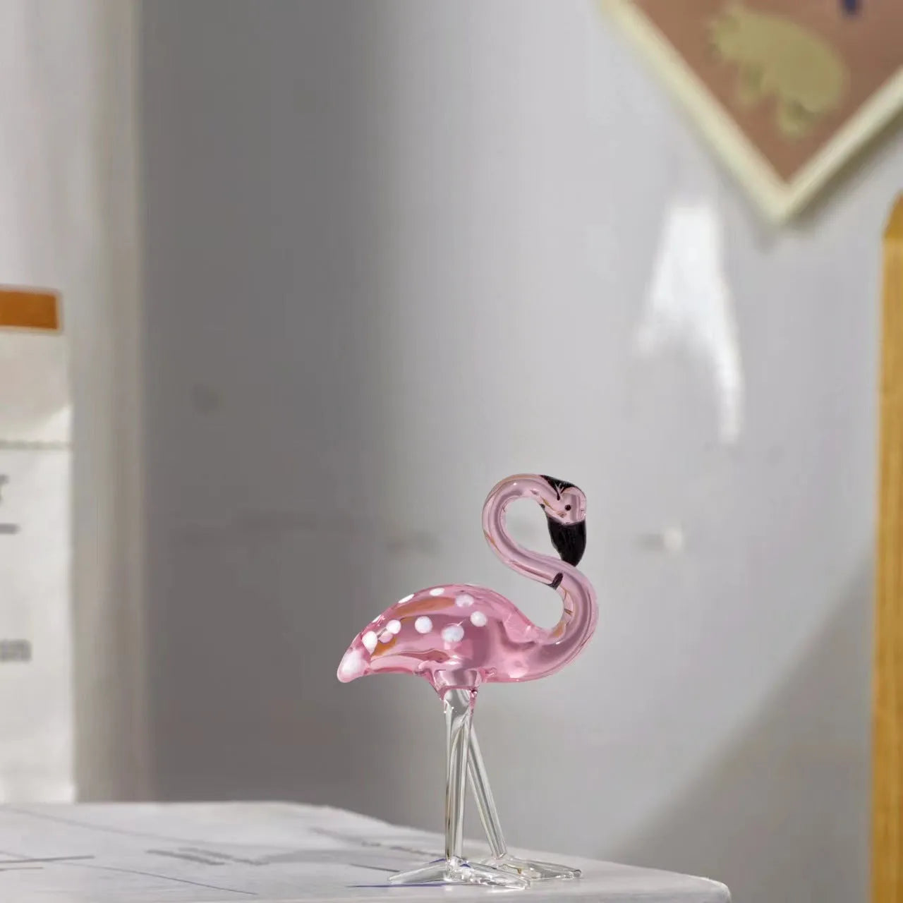 Pink and white crystal flamingo decorative ornament on a table.