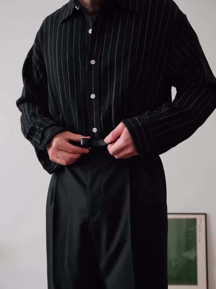 Men's black pinstriped polyester button-down shirt laid flat, showing regular fit and striped pattern.