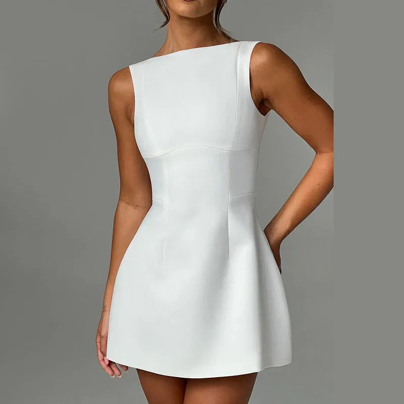A woman wearing a black backless sling dress with a high waist and short skirt.