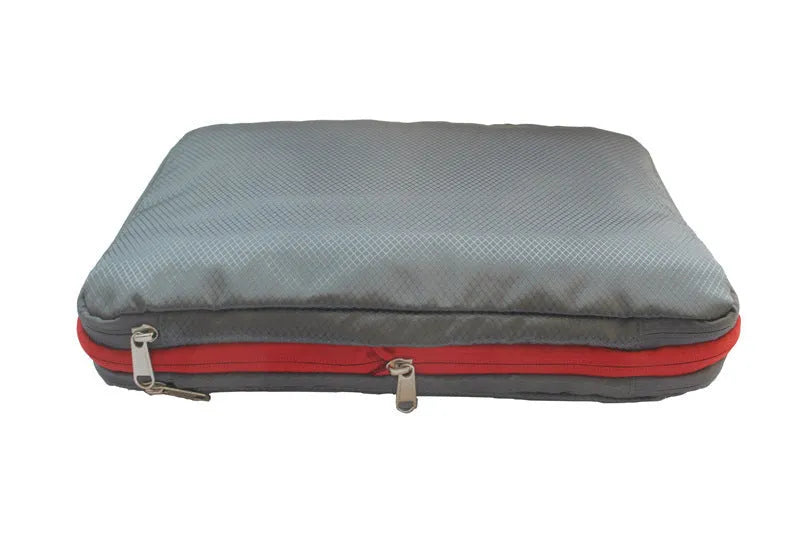 Green travel compression storage bag made of waterproof nylon in cube shape on a white background