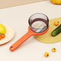 Light green kitchen peeler with integrated bucket storage for catching vegetable and fruit peels