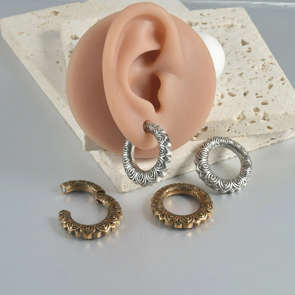 Pair of antique silver dragon-shaped geometric earrings with hollow-out design on a plain background.