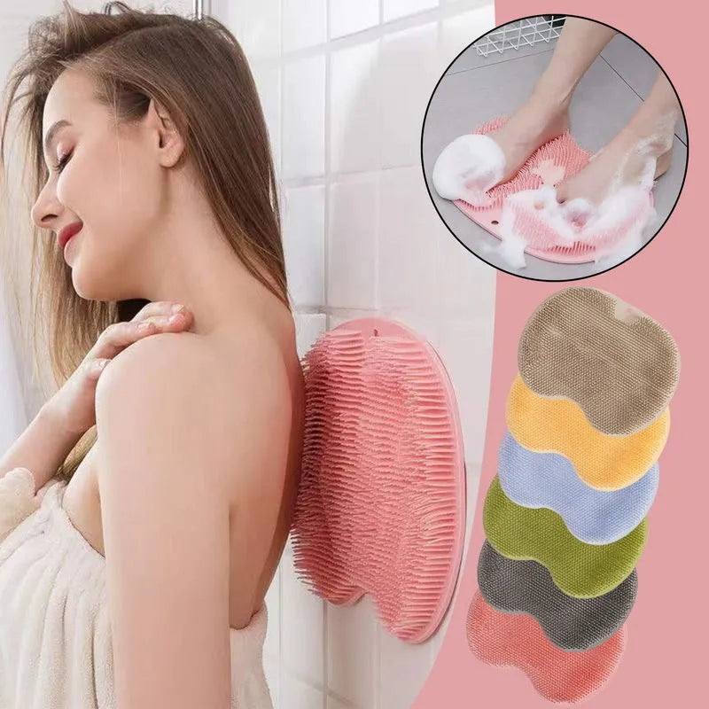 Orange non-slip bath brush with silicone bristles and suction cups on a bathroom floor.