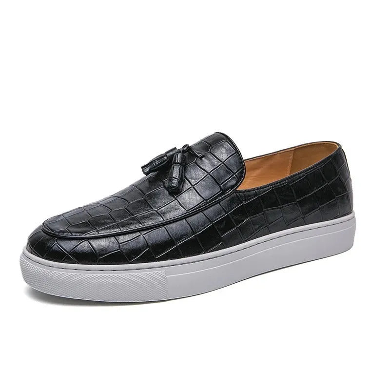 Men's black leather sneakers with a tassel detail on a round toe, shown on a white background.