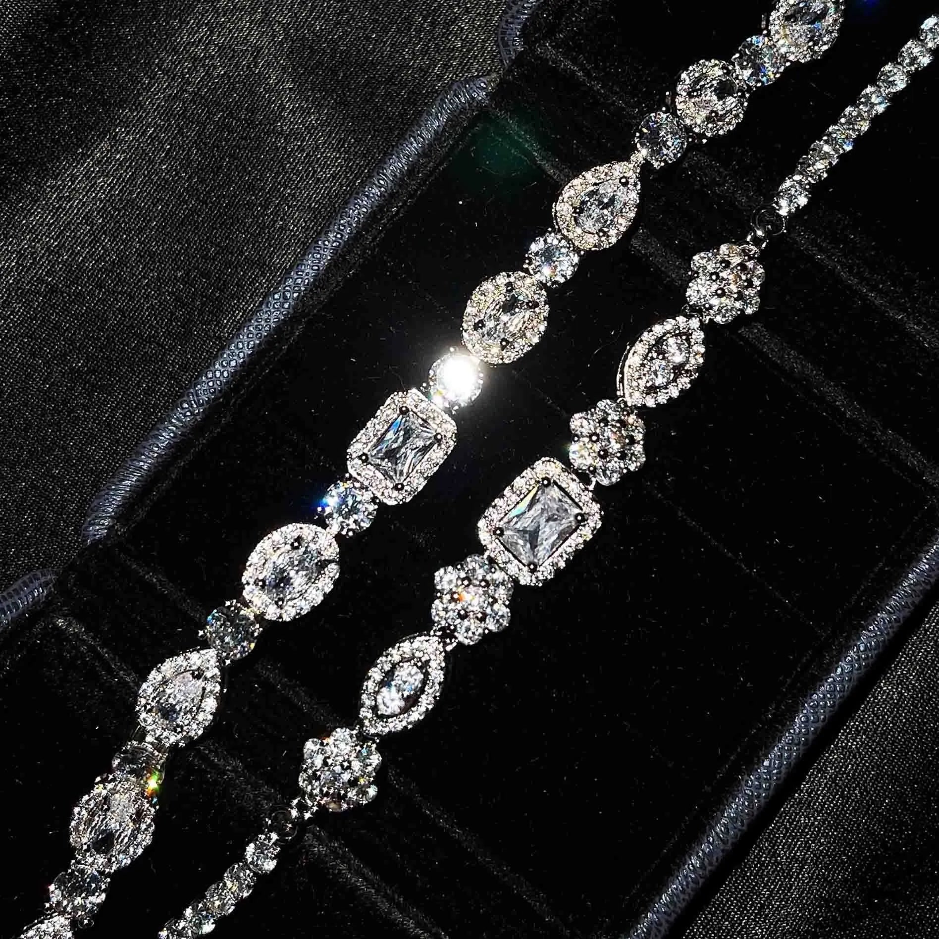 Close-up of women's geometric silver bracelet with inlaid zircon stones on a wrist, showing adjustable chain links.