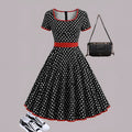Multicolour polka dot dress with square collar, short sleeves, front zipper, and pleated midi skirt on a hanger.