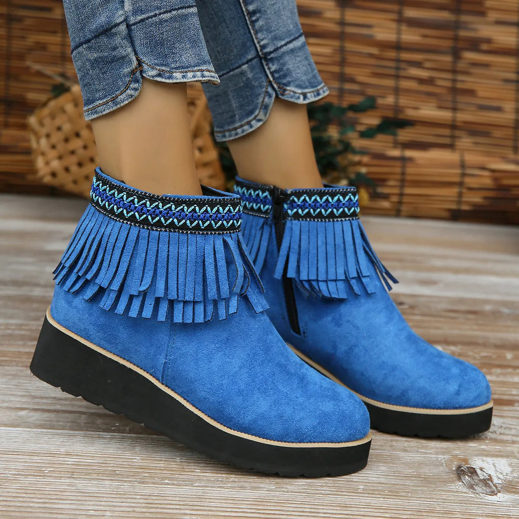 Women's suede ankle boots with wedge heel, side zipper, and tassel detail in dark brown.