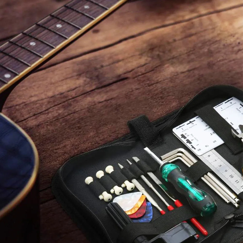 Open black guitar repair kit showing truss rod wrench, string action ruler, and cleaning tools in moulded plastic case