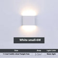 Rectangular LED outdoor wall lamp in black finish with warm light on a brick courtyard wall