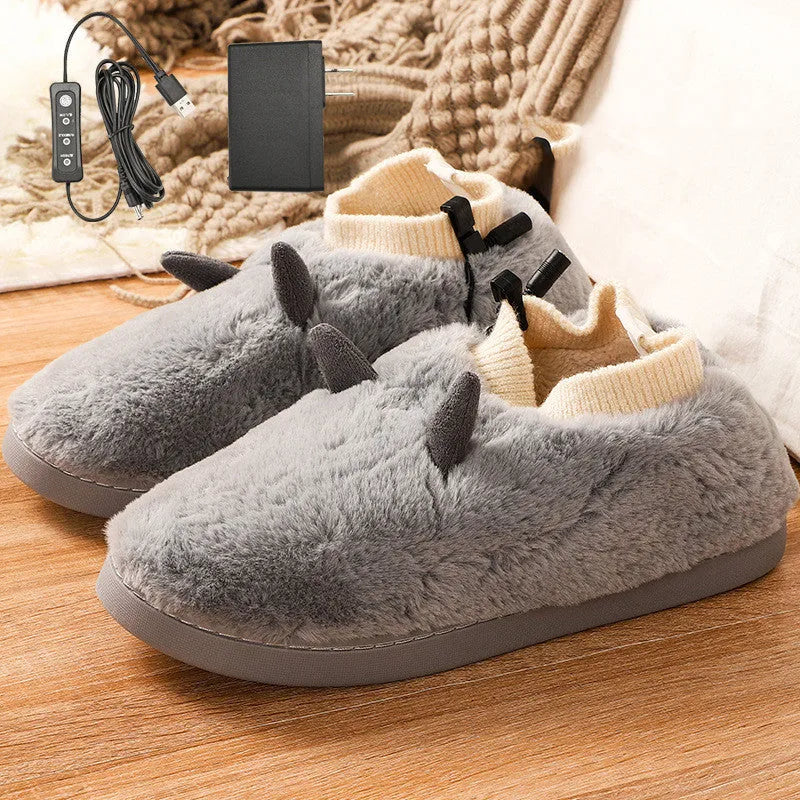 USB electric foot warmer slippers in grey with a connected USB cable on a wooden floor.