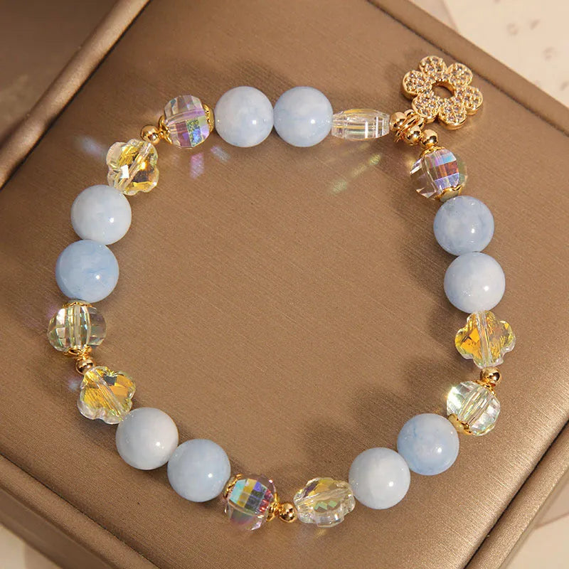 Aquamarine crystal bracelet with a four-leaf clover charm and pearl details for women.