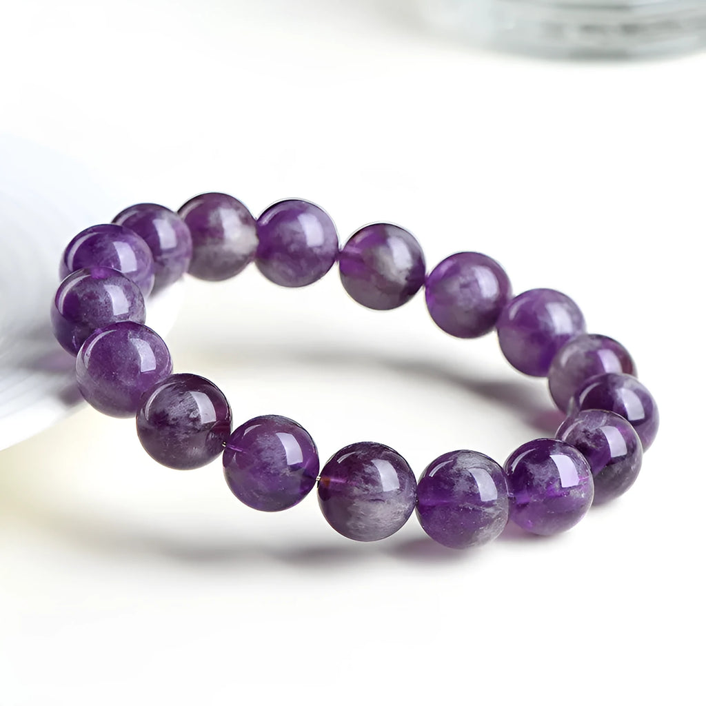 Natural feather amethyst bracelet with geometric Ruyi beads in snow mountain purple colour on a wrist.
