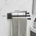 Black folding towel rack mounted on bathroom wall with adhesive installation