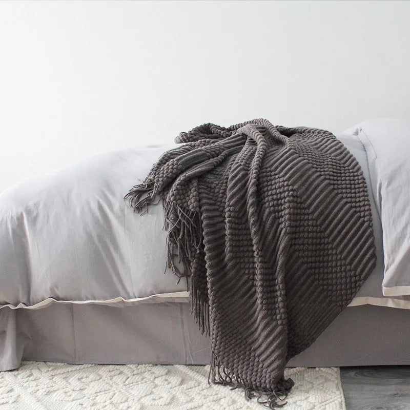 Small grey polyester nap blanket laid flat showing its size.