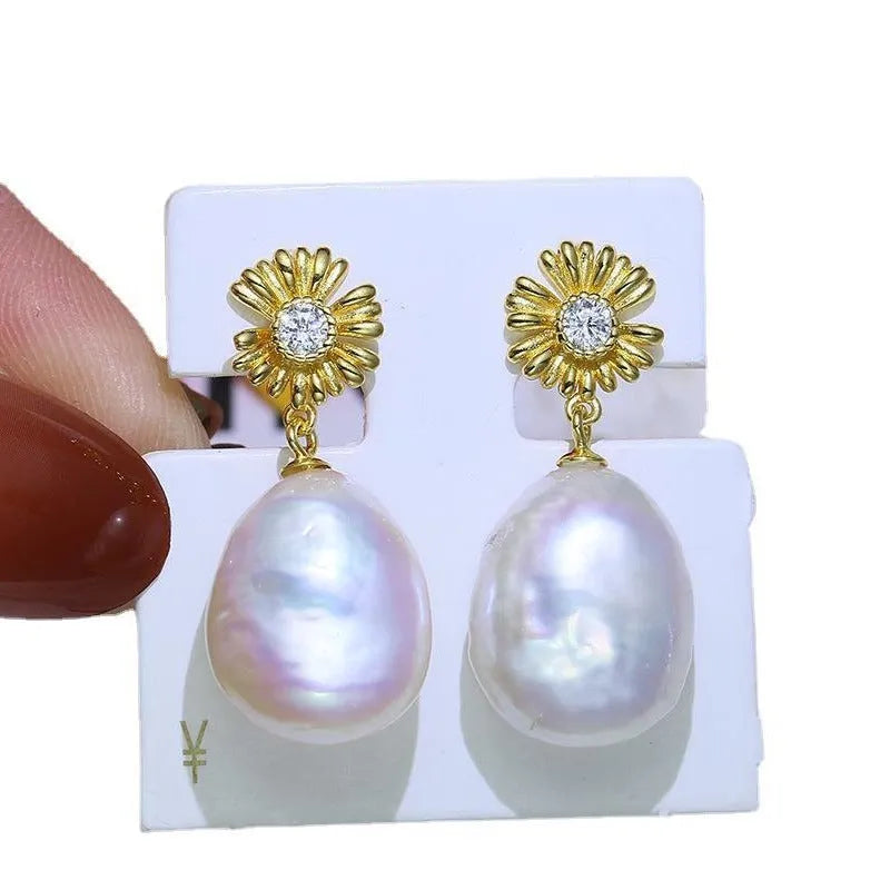 A pair of Baroque-style floral earring frames made of sterling silver, featuring a small integrated ring holder, presented without pearls.