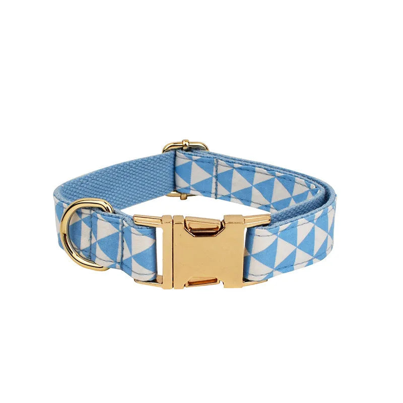Blue cloth dog collar, lead, bow, and vest set laid out flat showing the four matching pieces.