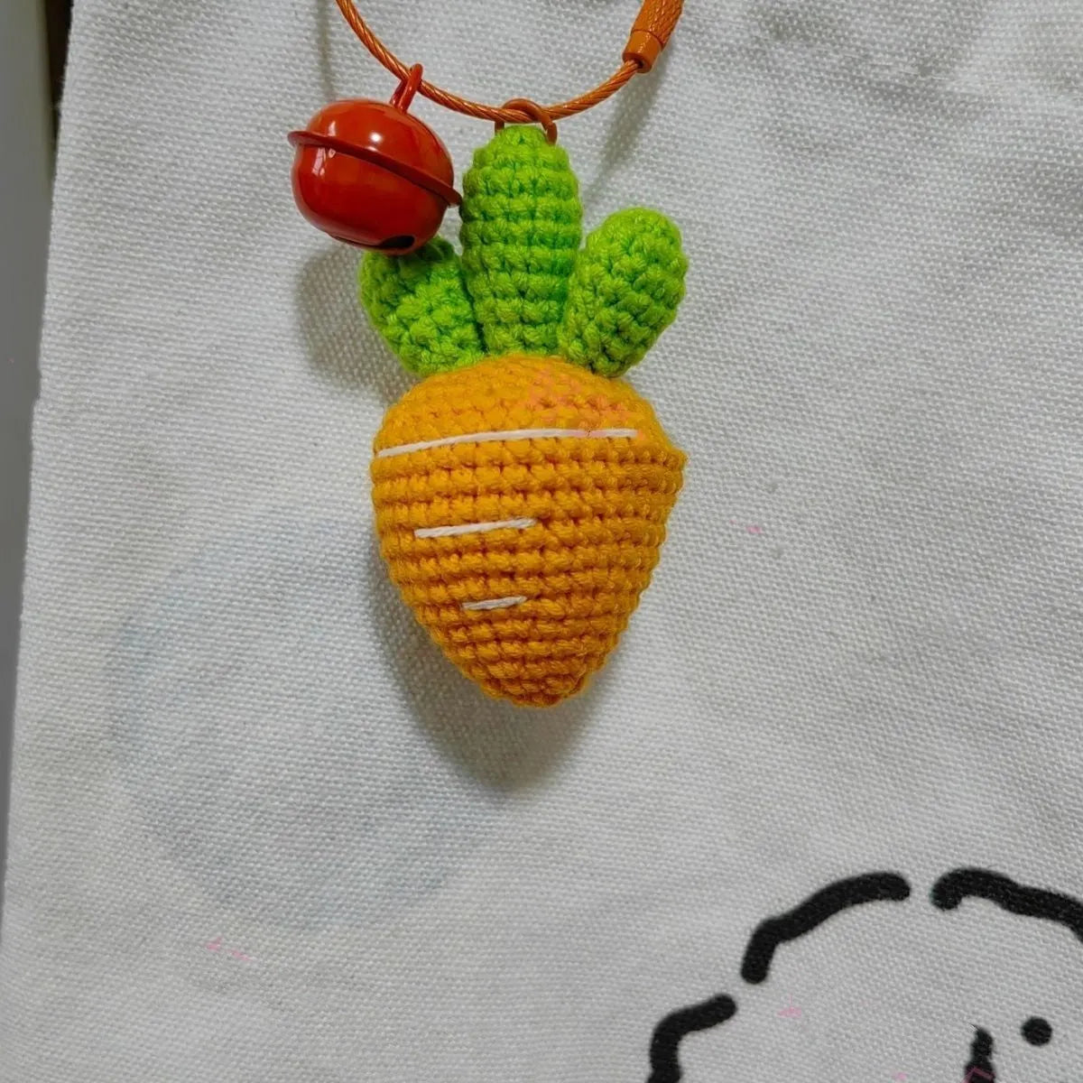 Soft wool keychain pendant shaped like a cartoon carrot car on a keyring.