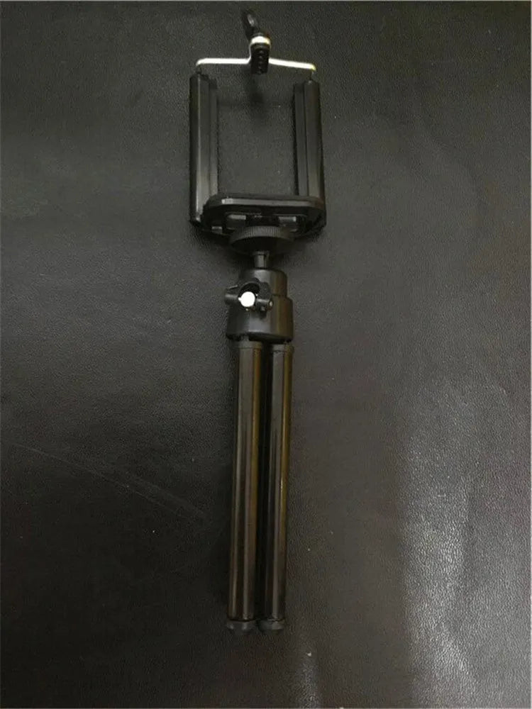 Black and silver desktop phone holder with two-section bracket on a desk.