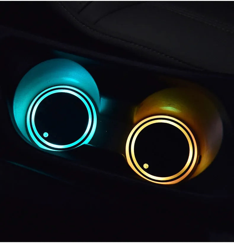 Colourful LED light-up car cup holder coaster with USB cable on a car centre console.