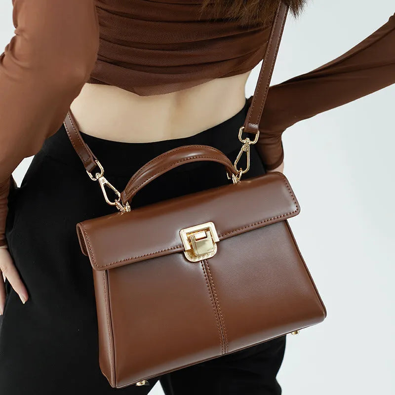 Dark brown women's genuine leather shoulder bag with a metal Vachette clasp, shown open to reveal an interior zippered pocket.