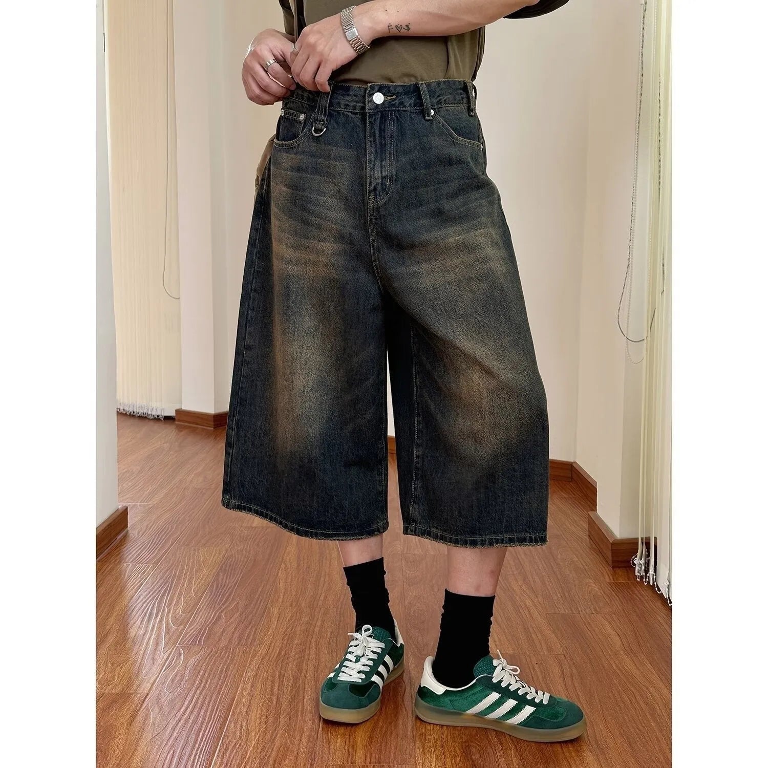 Men's straight-leg blue denim shorts with a loose fit and fifth pants length on a neutral background.
